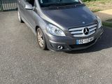grey mercedes b - class parked in front of a building in a parking lot