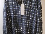 a close up of a shirt on a hanger on a wall