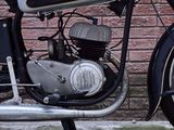 a black and white motorcycle parked in front of a brick wall