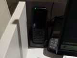 un téléphone portable posé sur un bureau, à côté d'un écran