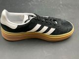 the adidas sneakers are black and white with gum soles