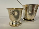 a silver cup with a spoon in it next to a silver cup with a spoon in it