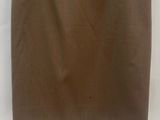a brown skirt hanging on a hanger against a white wall