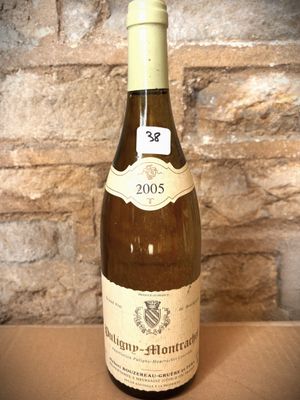 a bottle of wine sitting on a table in front of a brick wall