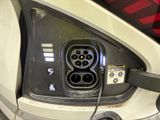 a close up of a car ' s rear end with an electric plug