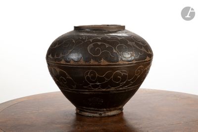un vase noir posé sur une table en bois