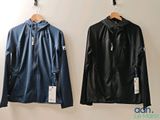 two jackets hanging up on a wall next to each other