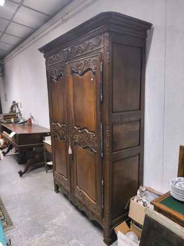 Armoire en chêne richement mouluré et sculpté, ouvrant à 2 portes...
