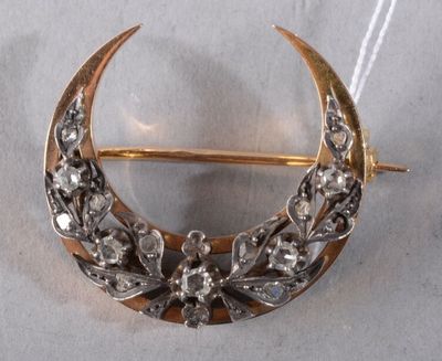 an image of a gold and silver crescent broochle with flowers