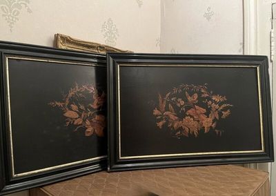 deux photos encadrées représentant des fleurs, posées sur une table à côté d'un miroir