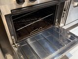 a silver oven with an open door in a kitchen