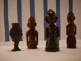 three wooden figurines sitting on a white table