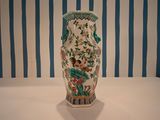 a vase that is sitting on a table in front of a striped wall