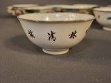 two bowls with asian writing on them sitting on a table
