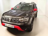 une photo d'une voiture noire et rouge garée dans un garage