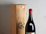 a bottle of wine sitting next to a wooden box