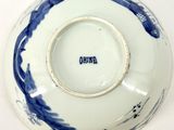 a blue and white bowl on a table with writing on it