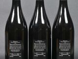 three bottles of wine sitting on top of a table next to each other