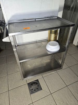 une table en acier inoxydable sur laquelle est posé un bol blanc