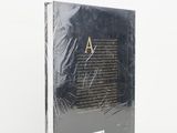 a book with a black cover sitting on top of a white surface