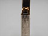 a silver lighter sitting on top of a white surface