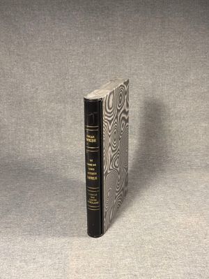 a black book sitting on top of a table next to a gray wall