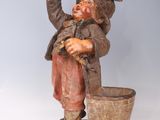 a statue of a man holding a bucket and a bird