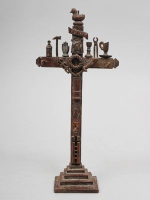 une vieille croix en bois sur laquelle sont accrochés tout un tas d'objets