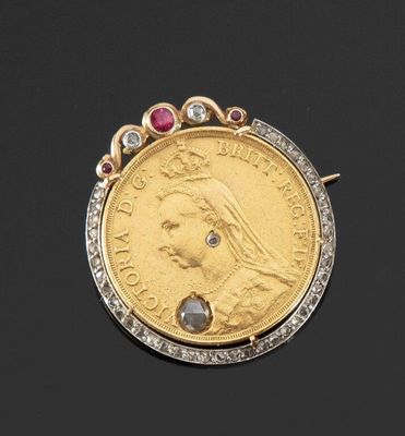 un gros plan d'une pièce d'or ornée d'un diamant et d'un rubis au centre