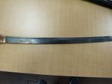 a sword on a table with a person standing next to it