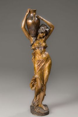 an antique bronze statue of a woman carrying a vase on her head