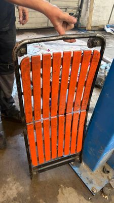 un homme qui se tient debout à côté d'une chaise orange