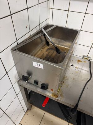 a dirty sink in a public restroom with a sign on it
