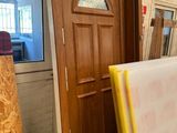 a room with a door, a window, and a pile of wood