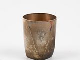 a glass with a design on it sitting on a table