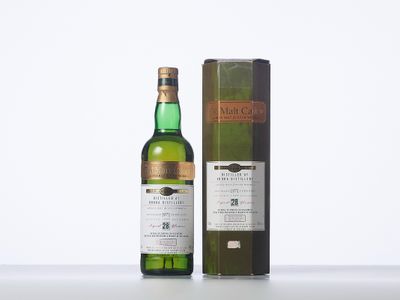 a bottle of whisky sitting next to a box on a table