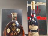 two bottles of brandy are sitting next to a box of wine