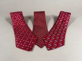 two red neck ties with different designs on them on a white surface
