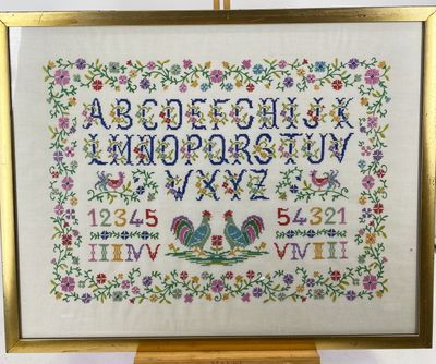 a cross stitched picture of a frame with a picture of a rooster on it
