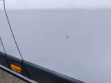 a white car with a hole in the side of it