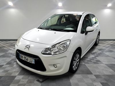 la petite voiture blanche est garée sur un carrelage à carreaux