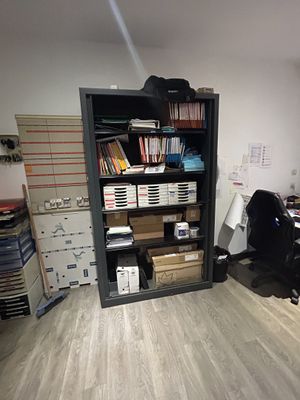 a room with a desk, a chair, and a bookcase