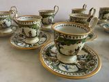 several cups and saucers are sitting on a table with a wall in the background