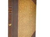 an old book with a brown cover sitting on top of a white surface