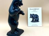 a black bear statue next to a book on a table