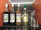 bottles of alcohol are lined up on a shelf in a kitchen