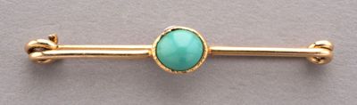 un gros plan d'un lingot d'or orné d'une pierre turquoise