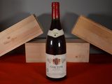 a bottle of wine sitting on a table next to a wooden box