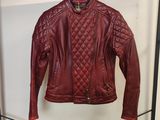 une veste en cuir suspendue à un portant dans un magasin de vêtements