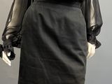 a mannequin wearing a black leather skirt and sheered blouse